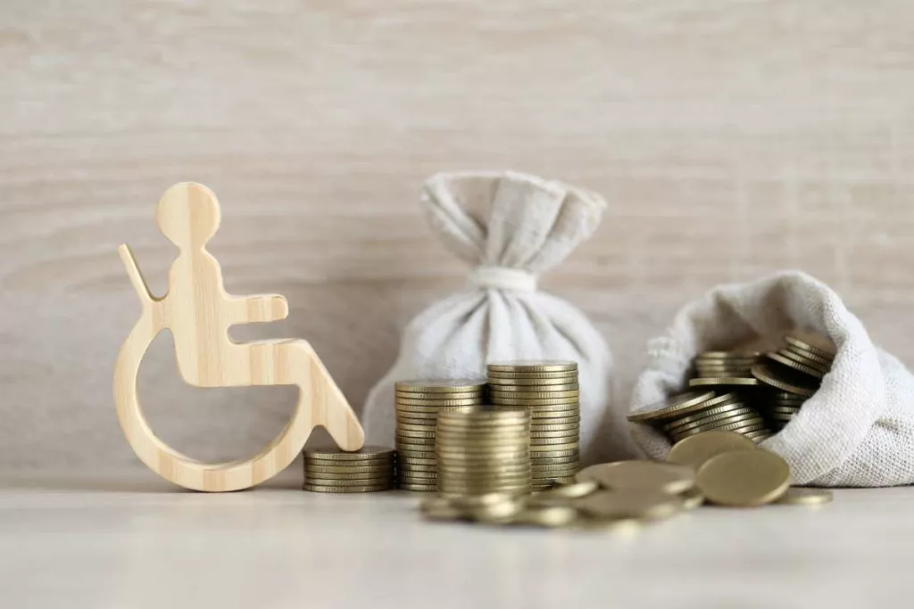 Gestion budget DGPH : de l'argent posé sur une table avec le symbole handicap